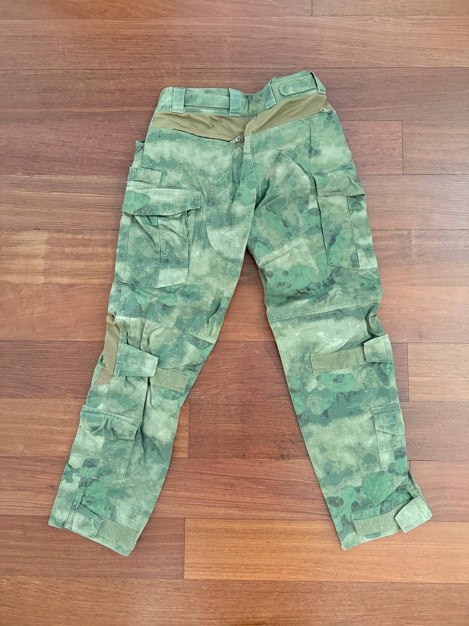 (USED) Russian Ars Arma Gen 3 Extreme Combat Pants - ATACS FG - Size 32L laid flat on a wooden floor, featuring a green digital camouflage pattern and multiple cargo pockets.