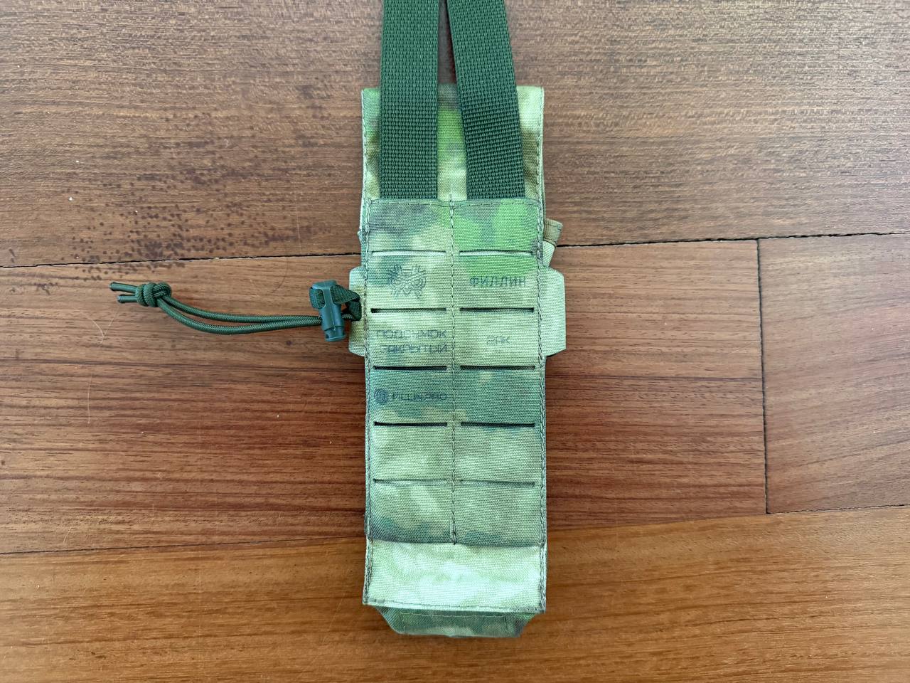 Russian Fillin Closed 2-AK Magazine Pouch - ATACS FG in camouflage pattern with sturdy green straps, designed for secure magazine storage, displayed on wooden surface.