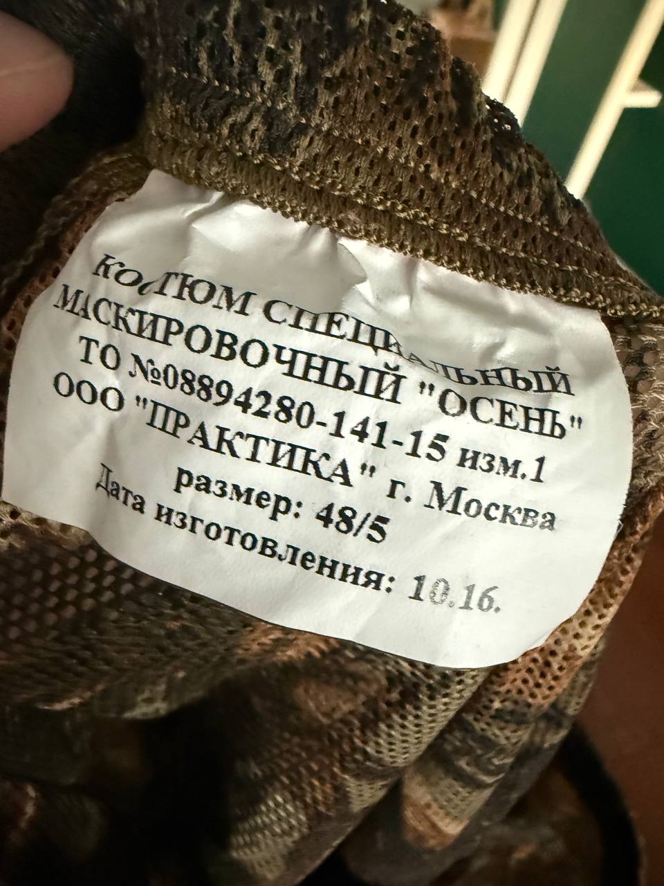 Close-up of the label inside a Russian Praktika Special Leaf Suit - Autumn Camo - FSB Contract - Size 48/5 showing Russian text and manufacturing details on camouflage fabric.