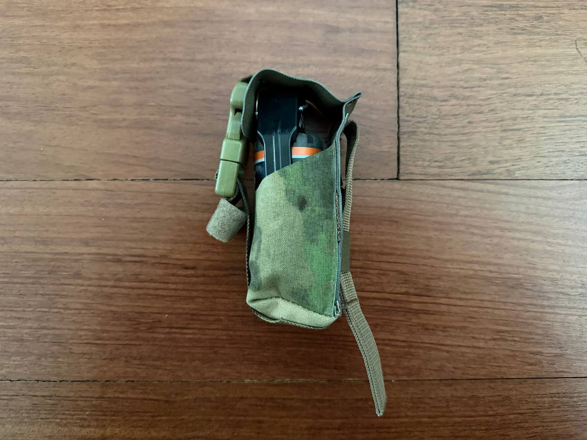 Russian Gear Craft MK3 Grenade Pouch - A-TACS FG Camo shown holding a grenade with green and brown camouflage pattern laid on wooden surface.