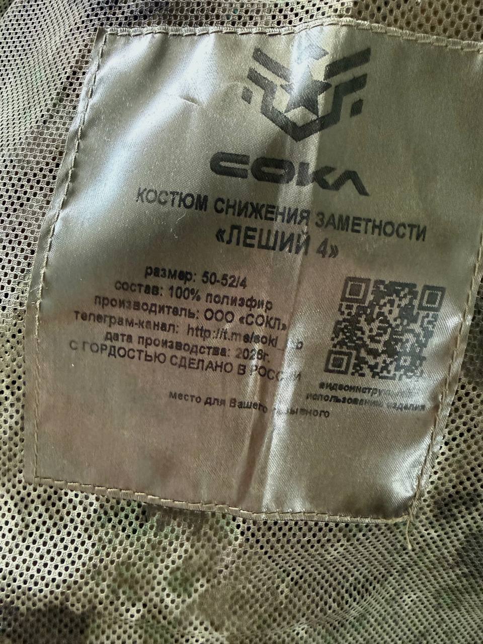 Close-up of the interior label on a Russian Sokl Leshy 4 Suit - Granite - Size 50-52/4, showing care instructions, fabric details, and a QR code on mesh fabric.