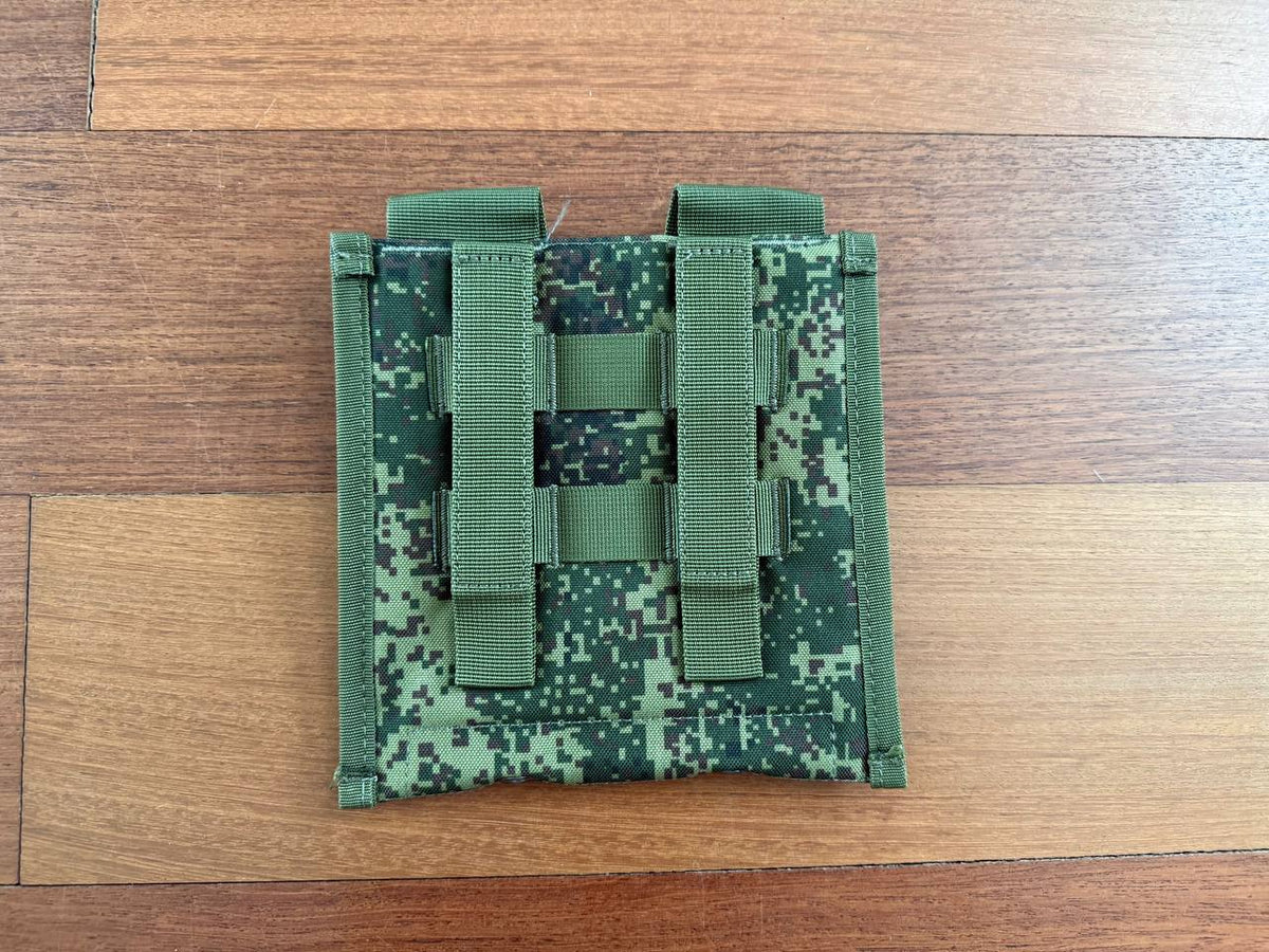Russian Triada-TKO Shovel Pouch - EMR Camo in green digital camouflage laid flat on wooden surface, showing two vertical straps and horizontal webbing for attachment.