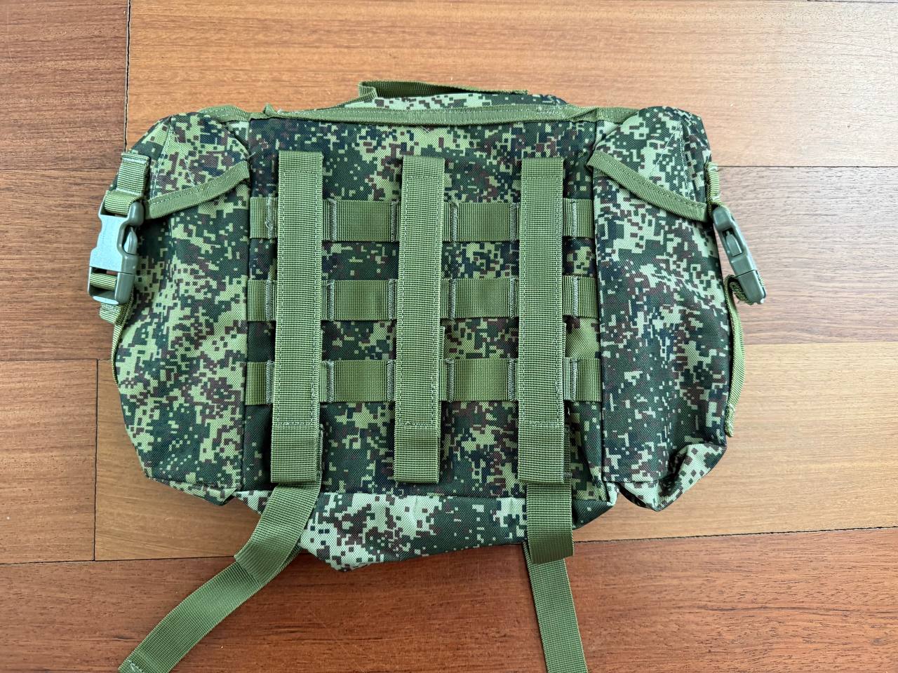 Russian Triada-TKO Tactical Buttpack - EMR Camo laid flat on a wooden surface, featuring durable straps and digital camo pattern suitable for tactical use and outdoor activities.