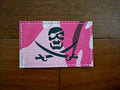 Russian "Jolly Roger" Pink Camo - Military Patch featuring a black skull and crossed swords design on a pink camouflage background, stitched edges for durability.
