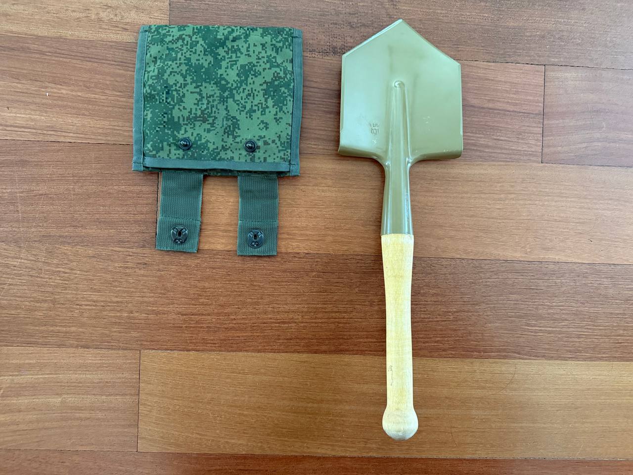 Russian Military Shovel & Tekhinkom Shovel Pouch Set displayed on wooden surface, featuring a green shovel with wooden handle and matching camouflage pouch.