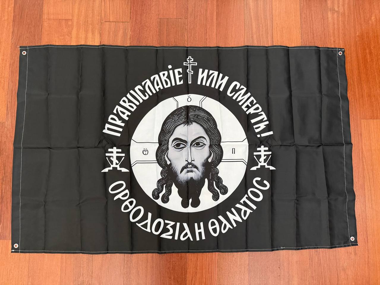 Russian "Orthodoxy or Death" Orthodox Flag - 150x90cm featuring a black background with a central religious icon and Cyrillic text, symbolizing Russian surplus faith themes.