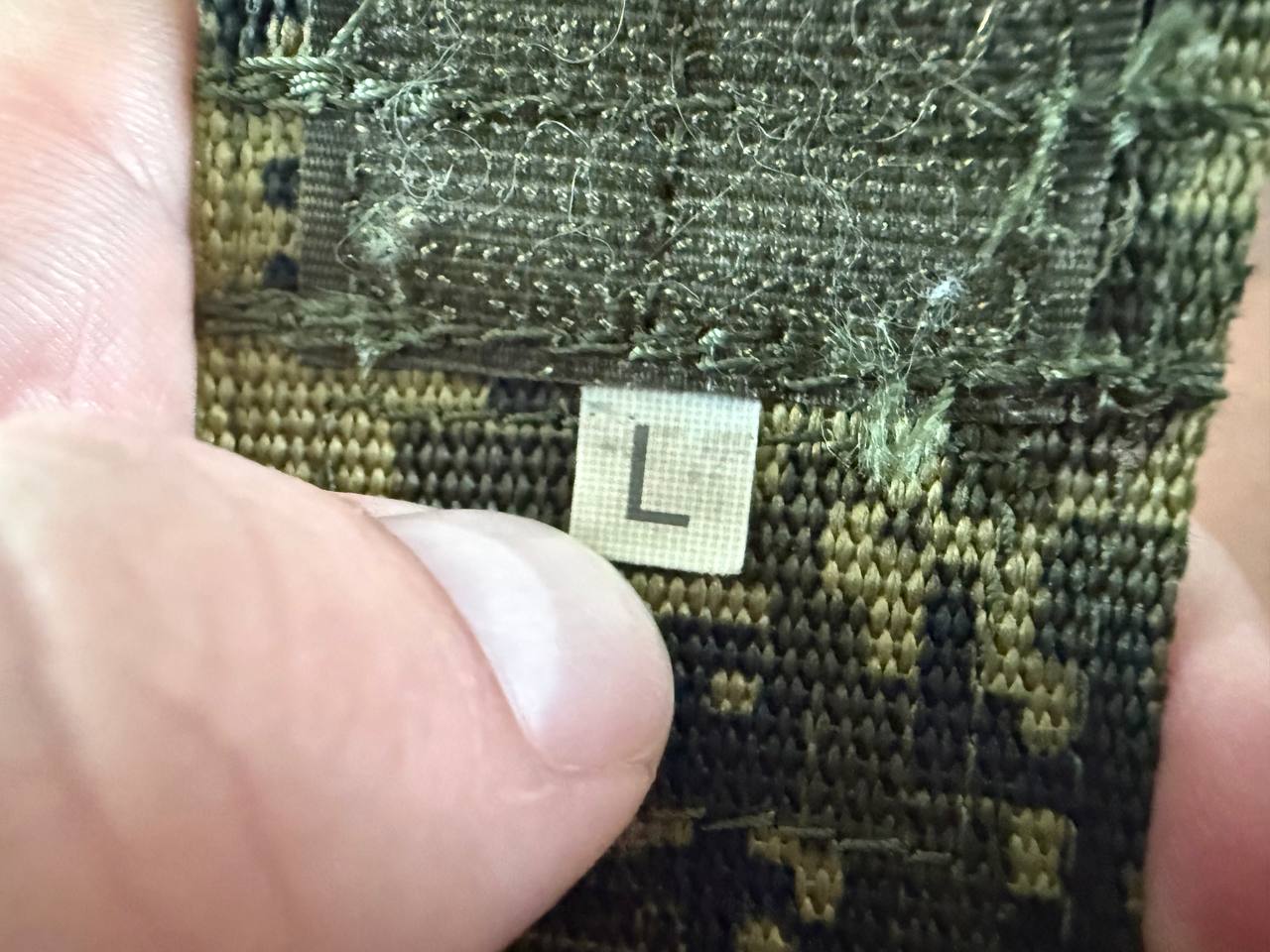 Close-up of a size L tag on a Russian Ars Arma Ronin Tactical Belt - EMR - L, showing detailed fabric texture and camouflage pattern.