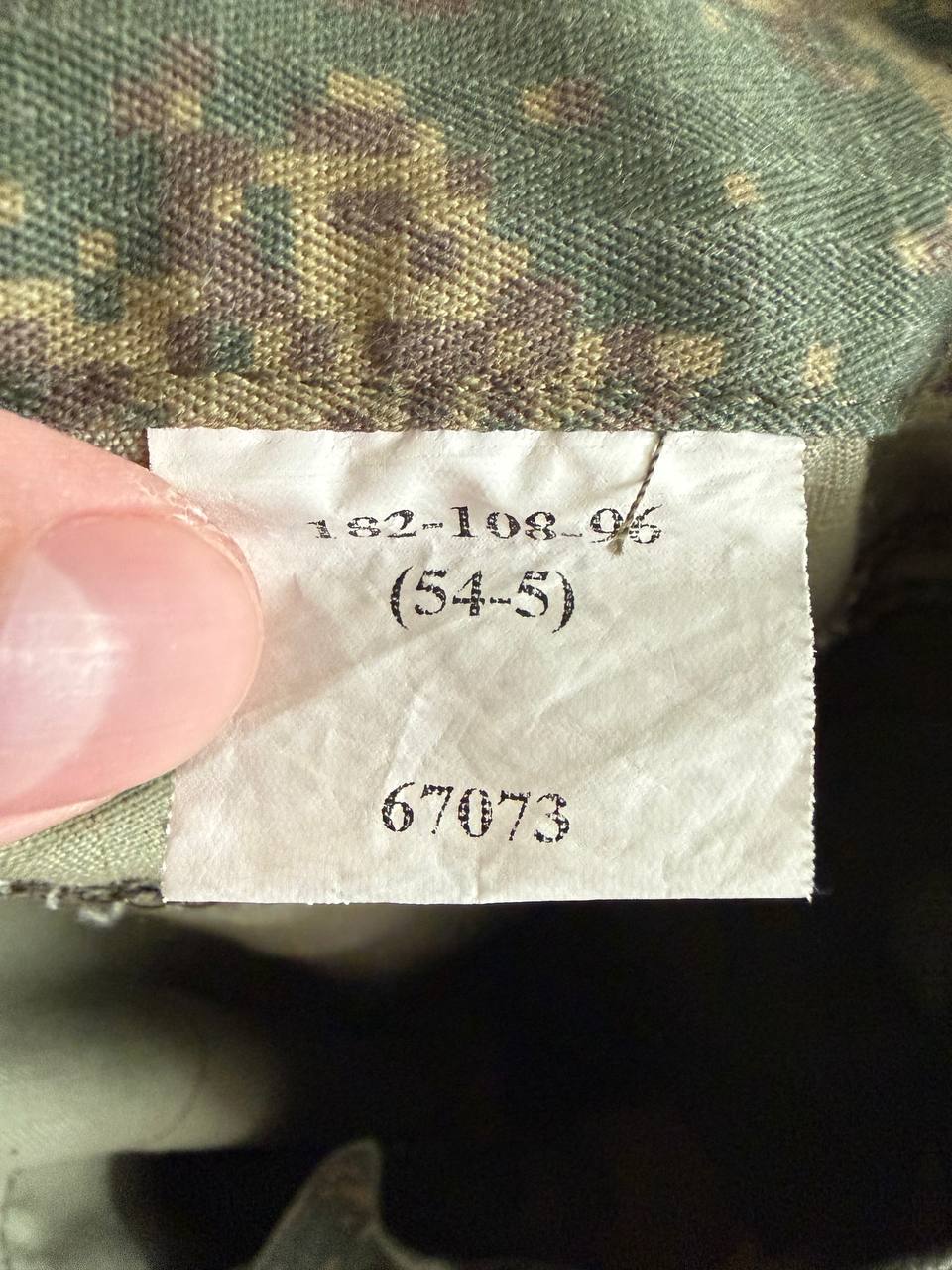 Close-up of a size label on a camouflage fabric showing the size code (54/5) inside a (USED) Russian 4 Layer Summer Suit - EMR Digital Flora - Size 54/5, highlighting authentic Russian surplus military gear.