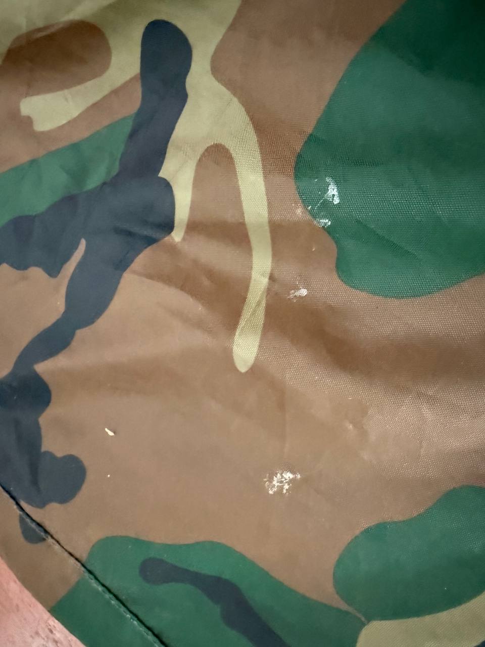 Close-up of camouflage fabric detail on (USED) Russian Layer 6 Waterproof Windproof Suit - Size 96-100/182-188, showcasing durable water-resistant material with green, brown, beige, and dark pattern.