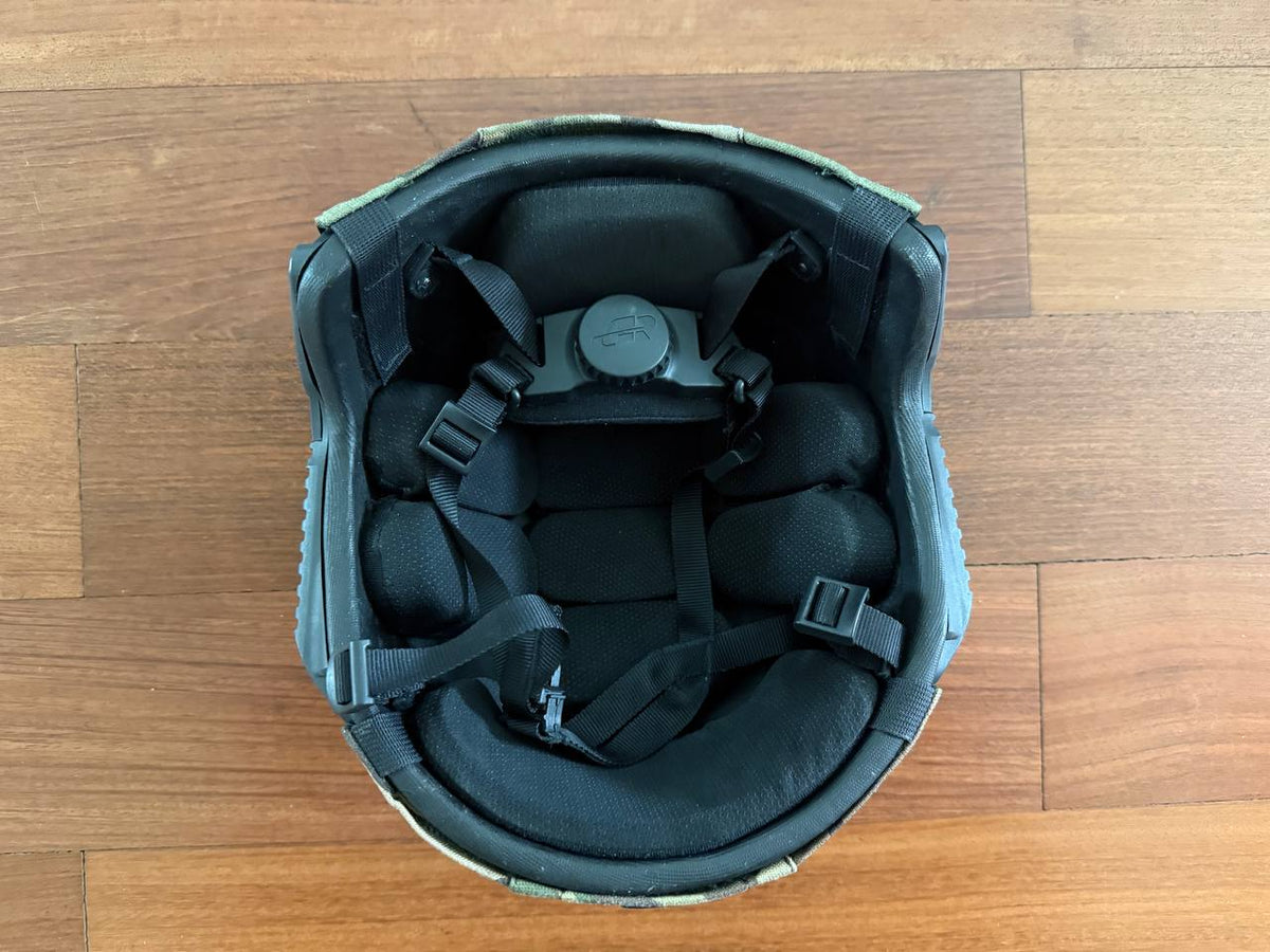 Interior view of the Russian LShZ 1+ Highcut Opscore Helmet - Size 3 + Multicam Cover showing padded cushioning and adjustable black straps on a wooden surface.