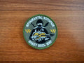 The PMC Wagner Badge - Russian Army Military Patch from Tanki Store features a soldier with a guitar, Russian text, “1/20” in yellow, and a green border—ideal for collectors seeking quality patches at the best price.