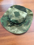 Green camouflage panama hat with a patch on a wooden surface